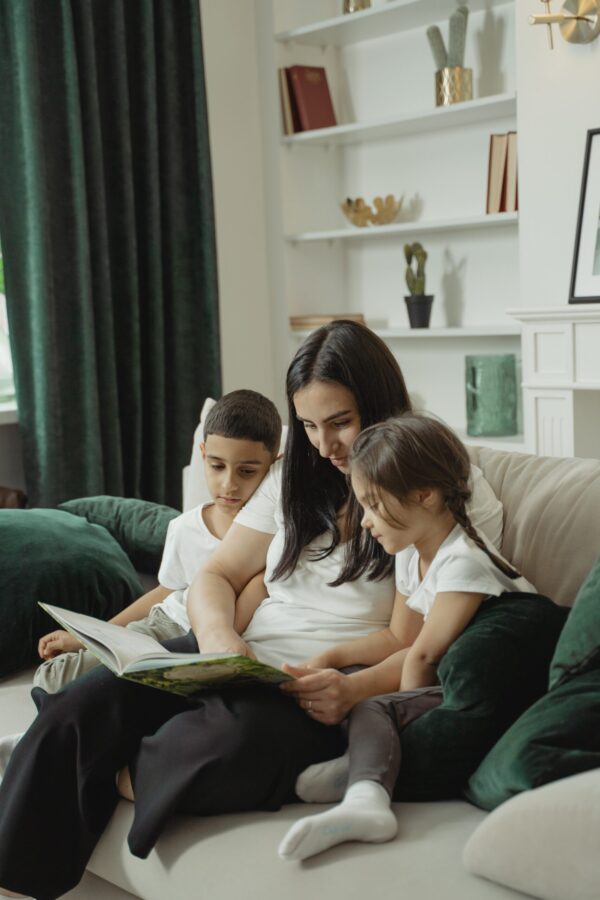 Mom reading with two kids on a couch